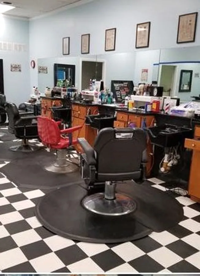 The wall inside Red Bank Barber Shop lined with framed pieces above the barber stations